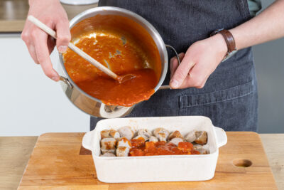 Currysauce über die Würste geben