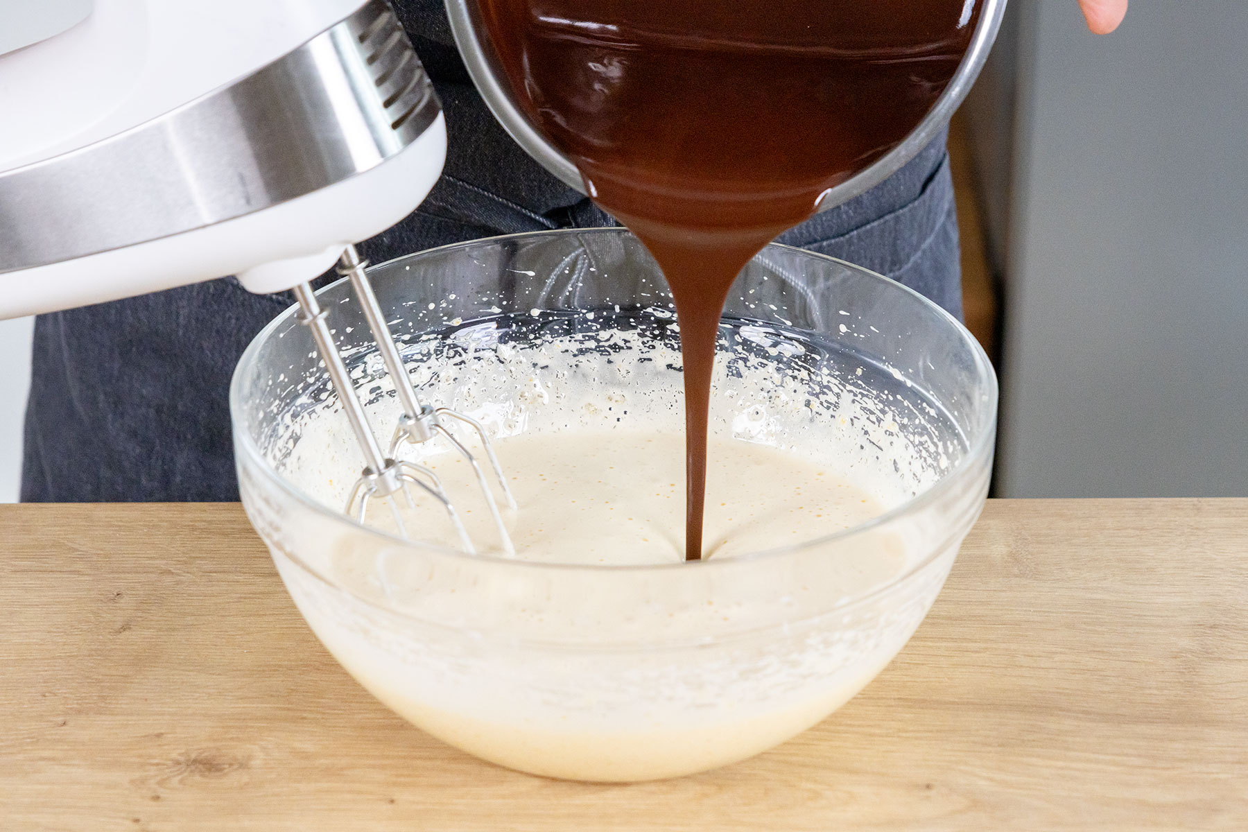 Schokolade zur Zuker-Ei-Masse gießen