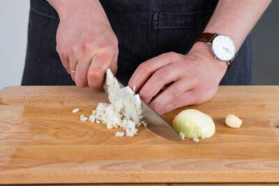 Knoblauch und Zwiebel in kleine Würfel schneiden.