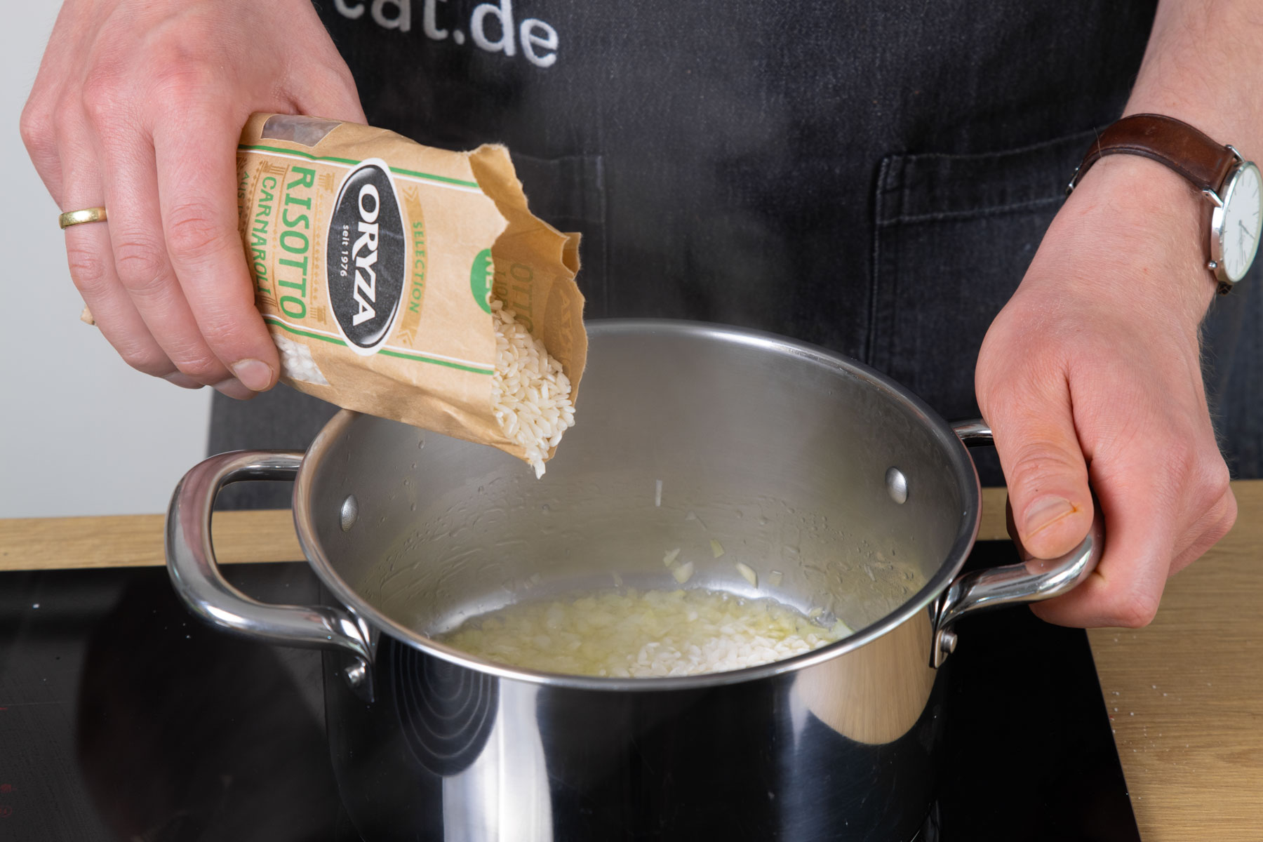 Den Risotto Reis mit Knoblauch Zwiebeln anschwitzen.