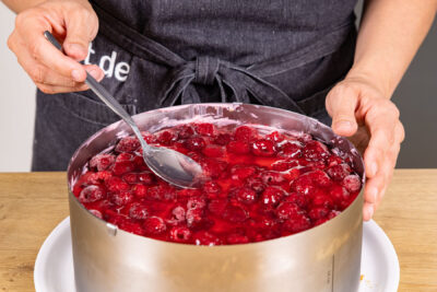 Tortenguss über Himbeeren gießen