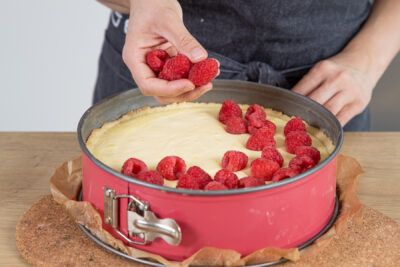Käsekuchen mit Himbeeren bedecken