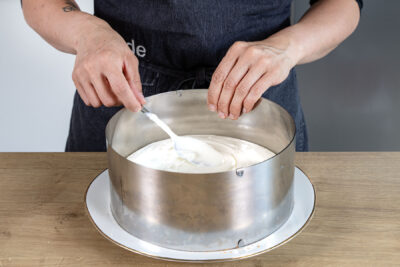 Käsesahnecreme auf Tortenboden verstreichen