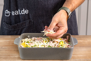 Kartoffel-Schinken-Gratin mit Käse bestreuen