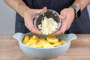 Zwiebeln und Knoblauch in Auflaufform geben