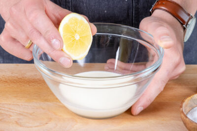 Zitronensaft zu der Sahne geben