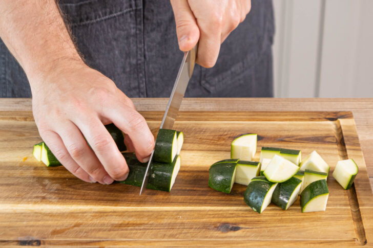 Zucchini und Paprika in Würfel schneiden