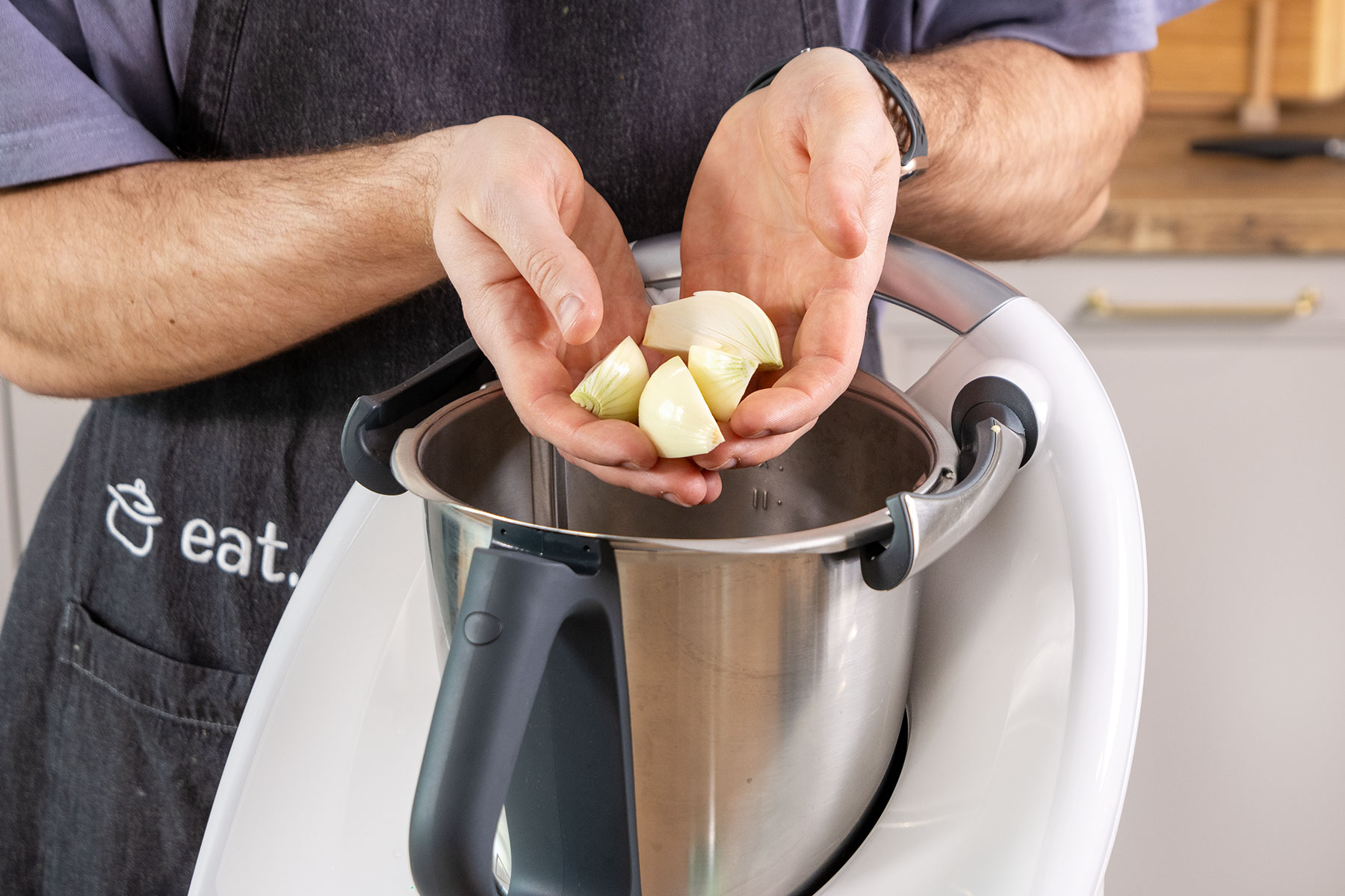Zwiebelstücke in den Mixtopf geben