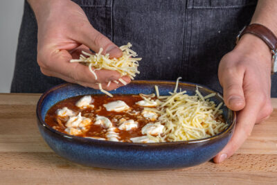 Makkaroni-Auflauf mit Hackfleisch mit Käse bestreuen