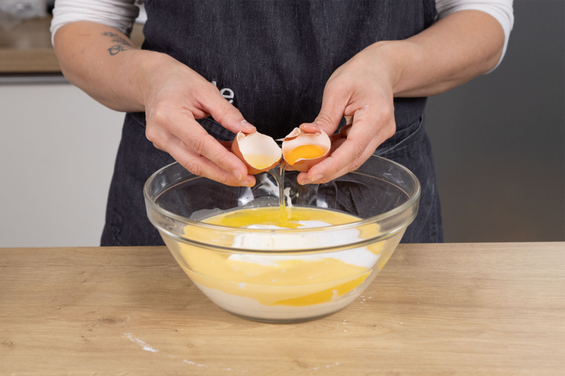 Schmand, Zucker, Eier und das angerührte Puddingpulver glattrühren und auf den Mürbeteigboden geben.