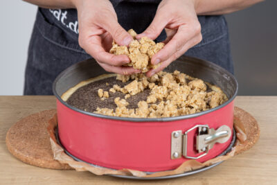 Streusel auf dem Mohnkuchen verteilen