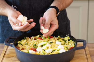 Die Mozzarella-Kugeln über dem Gemüse und den Nudeln verteilen.