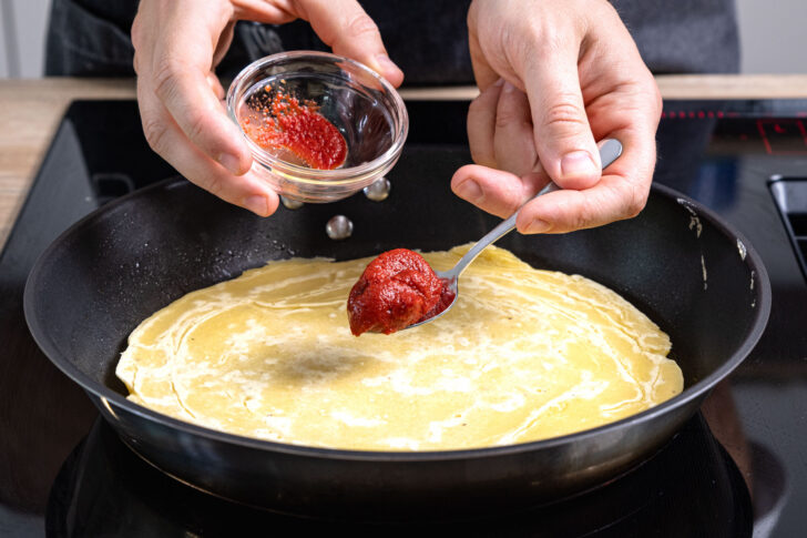 Pfannenpizza mit Tomatenmark bestreichen