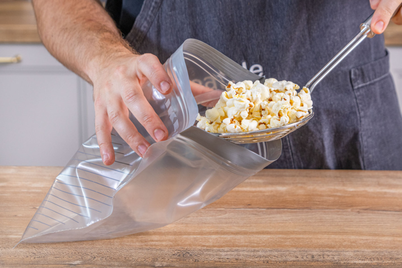 Popcorn in eine Tüte füllen