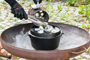Briketts unter und auf dem Dutch Oven verteilen
