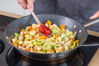 Tomatenmark zum Wurzelgemüse geben