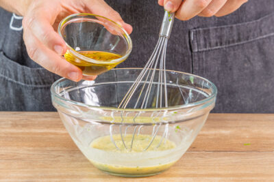 Öl langsam in die restlichen Zutaten für die schnelle Salatsauce geben
