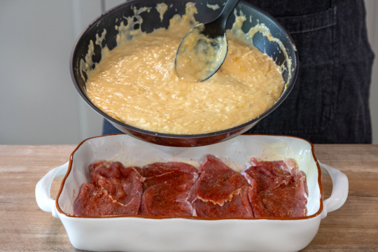Schnitzelpfanne mit Zwiebelsuppen-Sauce bedecken