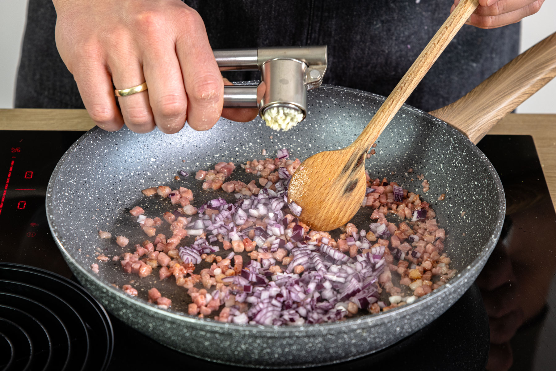 Zwiebel und Knoblauch in Pfanne geben