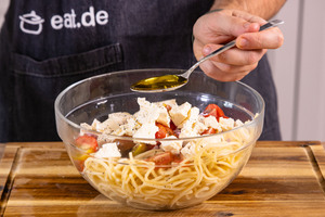 Olivenöl zu Spaghettisalat geben