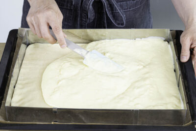 Puddingmasse auf dem Hefeteig verstreichen