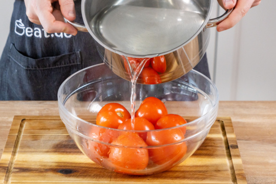 Kochendes Wasser über die Tomaten gießen