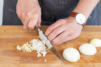 Zwiebeln und Knoblauch schälen und fein würfeln