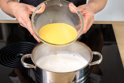 angerührtes Puddingpulver zur Milch geben