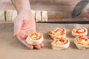 Vegetarische Pizzaschnecken auf dem Backblech verteilen