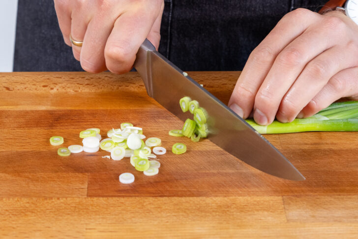 Frühlingszwiebel in Streifen schneiden