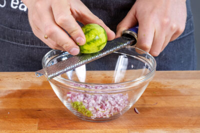 Limettenschale zur Zwiebel reiben