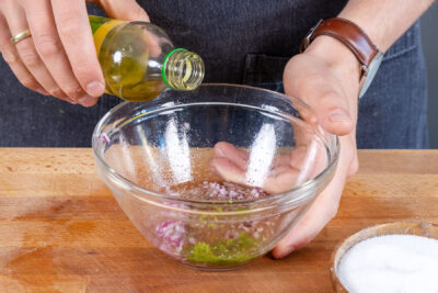 Olivenöl zum Dressing des Grünkernsalats geben