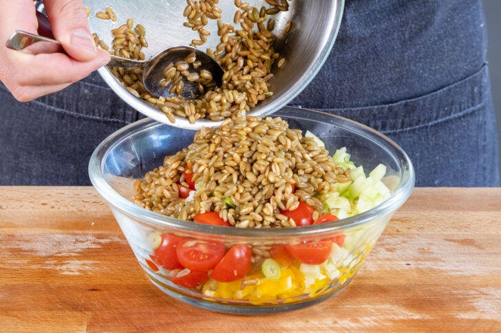 gekochte Grünkerne zu dem Salat geben
