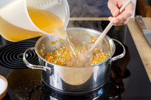 Gemüsebrühe zur Suppe gießen
