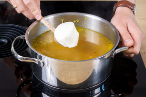 Crème fraîche zur Grünkernsuppe geben