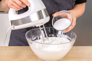 Zucker in Eischnee einrieseln lassen