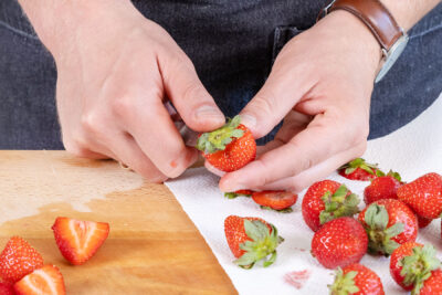 Grün der Erdbeeren abschneiden