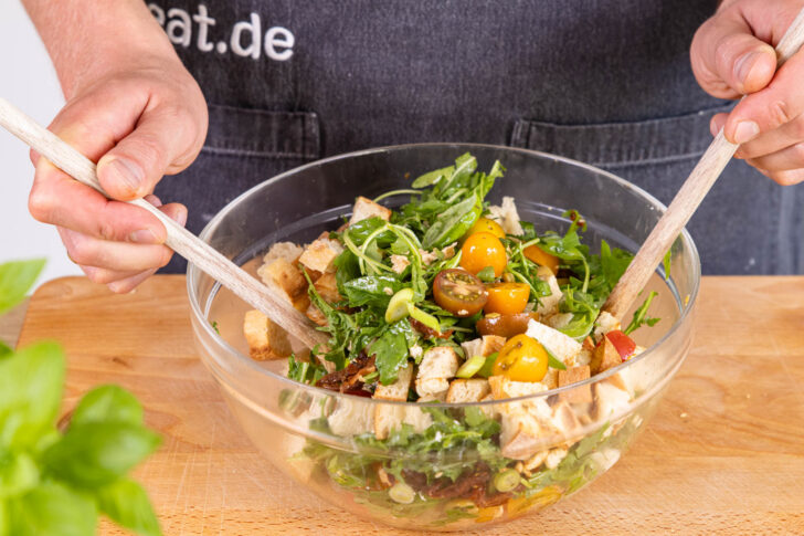 Mediterranen Brotsalat vermengen