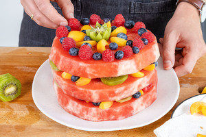 Melonentorte mit dem restlichen Obst dekorieren