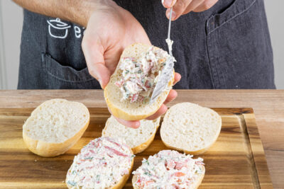 Pizzabrötchen mit Pizzabelag bestreichen