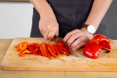 Paprika in feine Streifen schneiden.