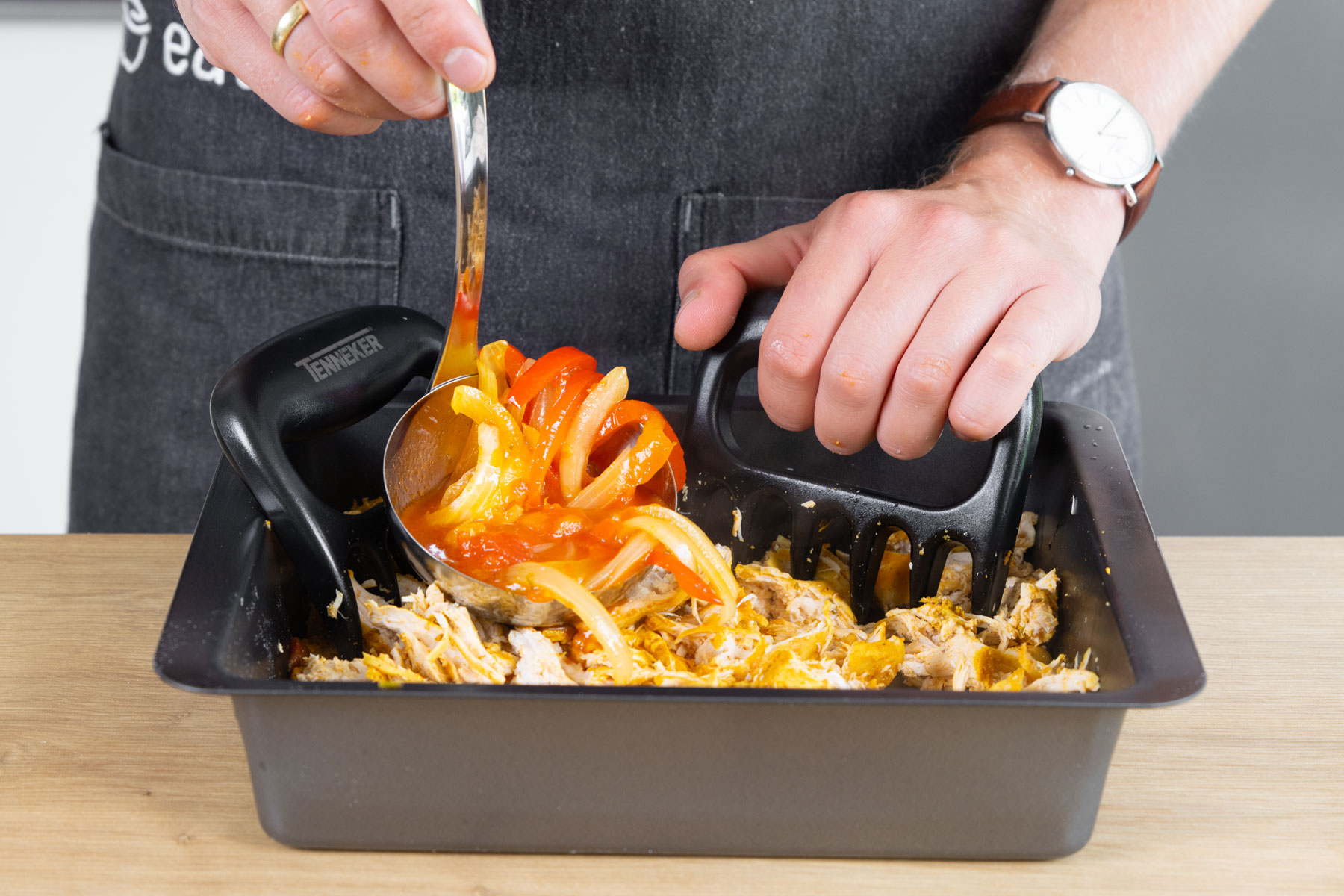 Paprika und Soße zu dem gerupften Hähnchen geben.