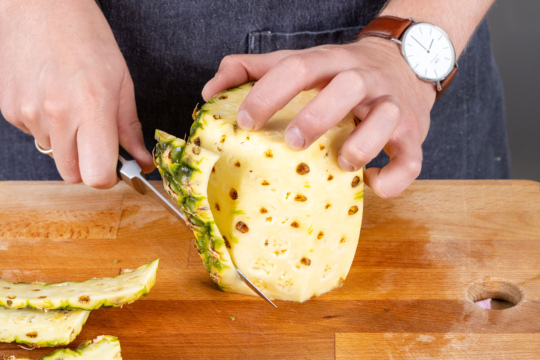 Schale der Ananas abschneiden
