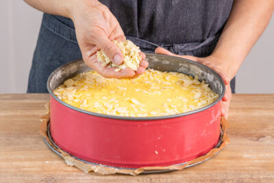 Mandelblättchen über Apfelkuchen streuen