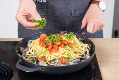 Spaghetti alle vongole mit Blattpetersilie bestreuen