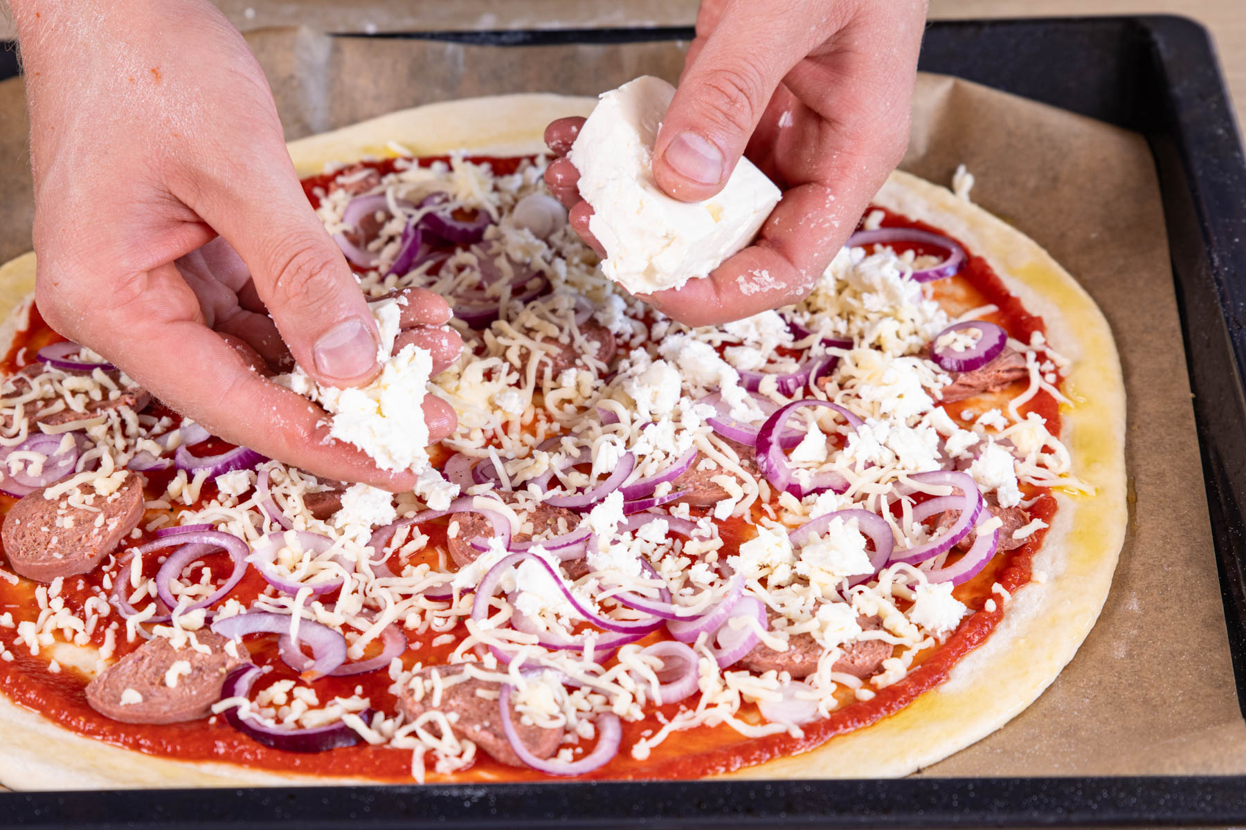 Feta auf Sucuk-Pizza verteilen