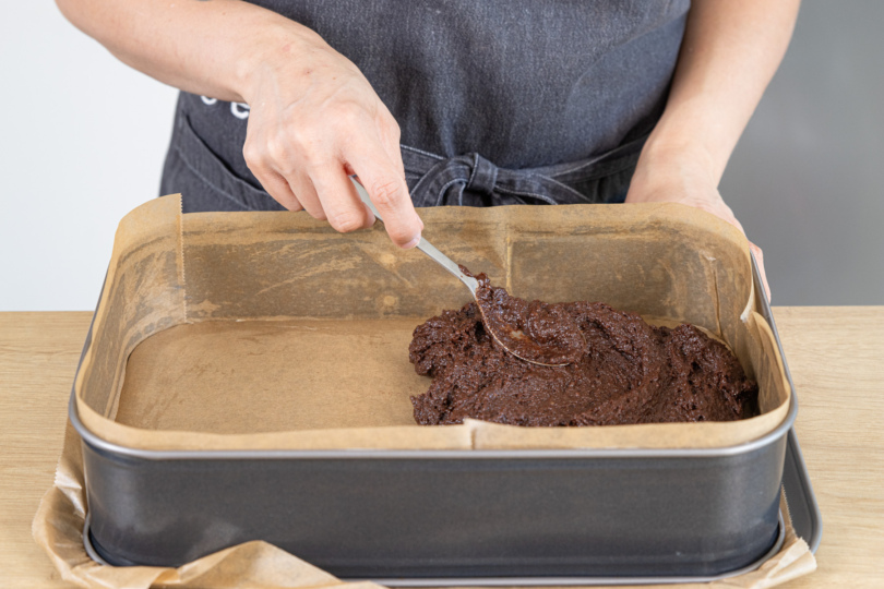 Teig für die veganen saftigen Brownies in der Form verstreichen