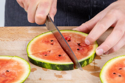 Wassermelonenscheiben in Stücke schneiden