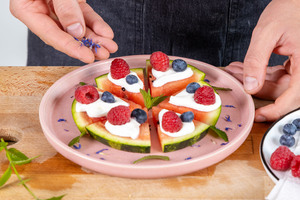 getrocknete Kornblumenblüten über die Wassermelonen-Pizza streuen