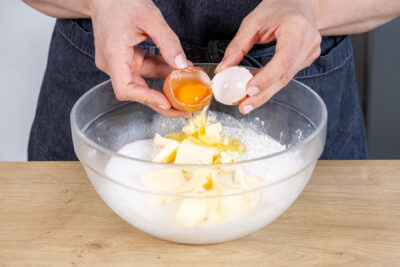 Eier und Butter zum Mehl geben